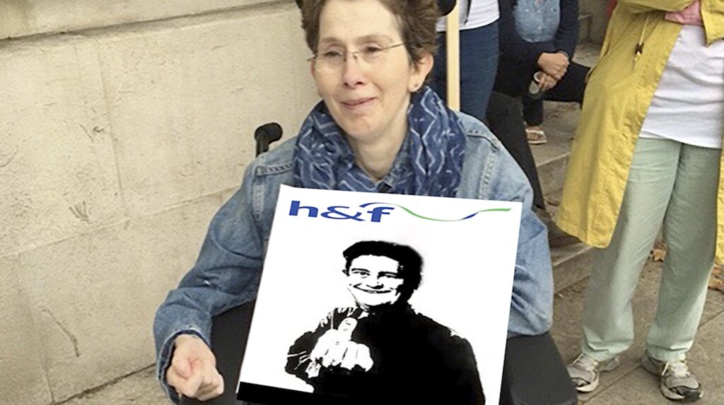 Debbie Domb holding a provocative campaigning placard